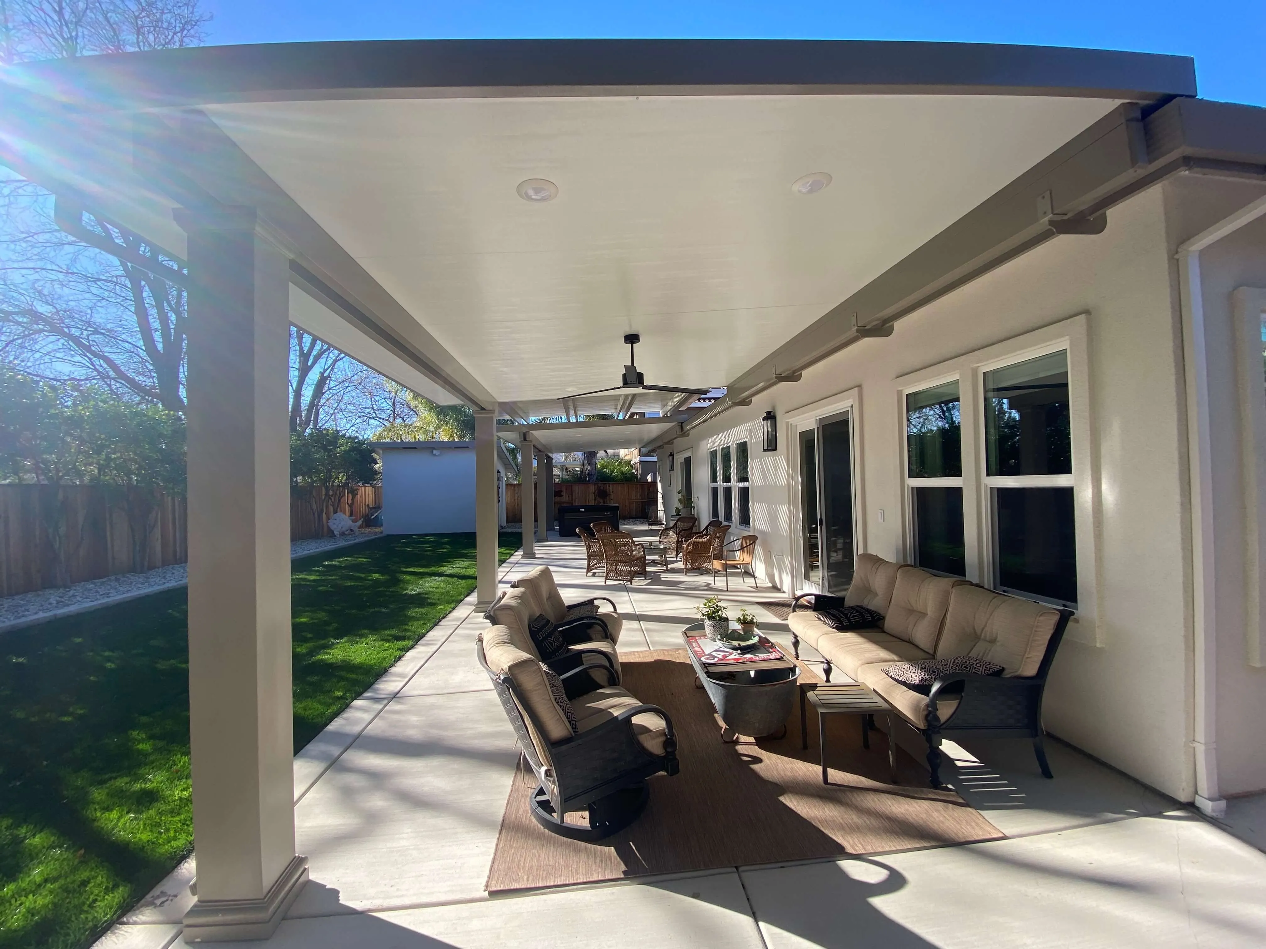 Long solid aluminum patio cover over a backyard patio