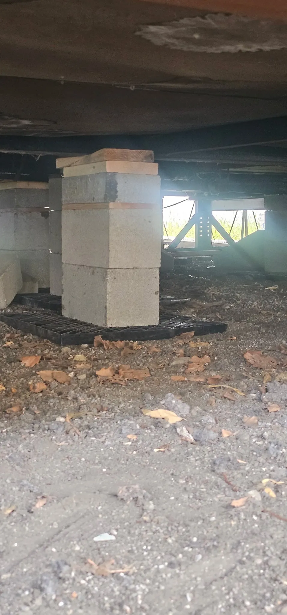 New pier set on a pad under the steel frame of a mobile home