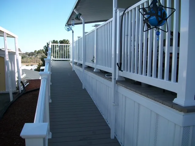 Long wheelchair ramp with white railings along a mobile home